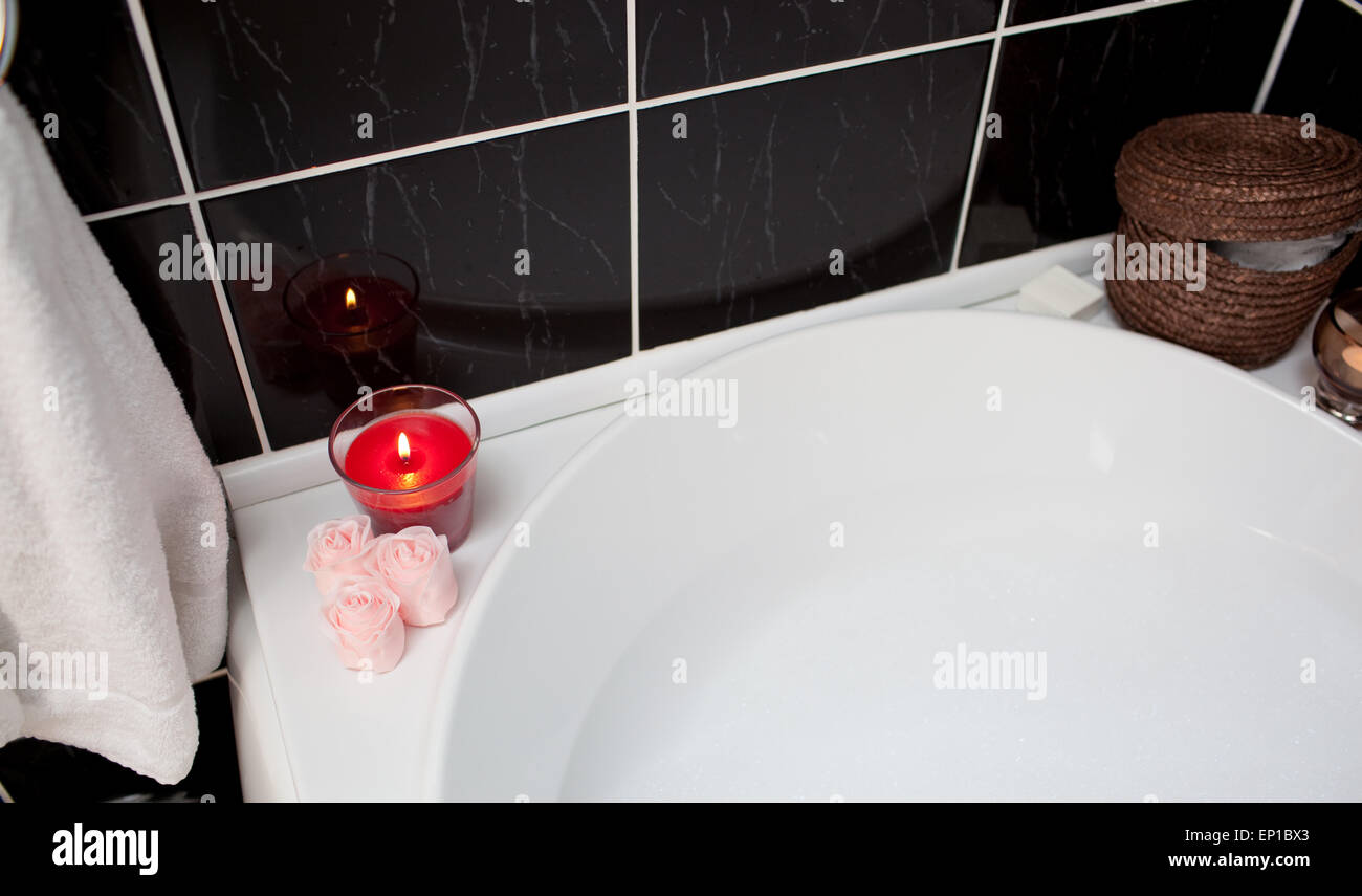 Bubble bath with candle and flowers Stock Photo