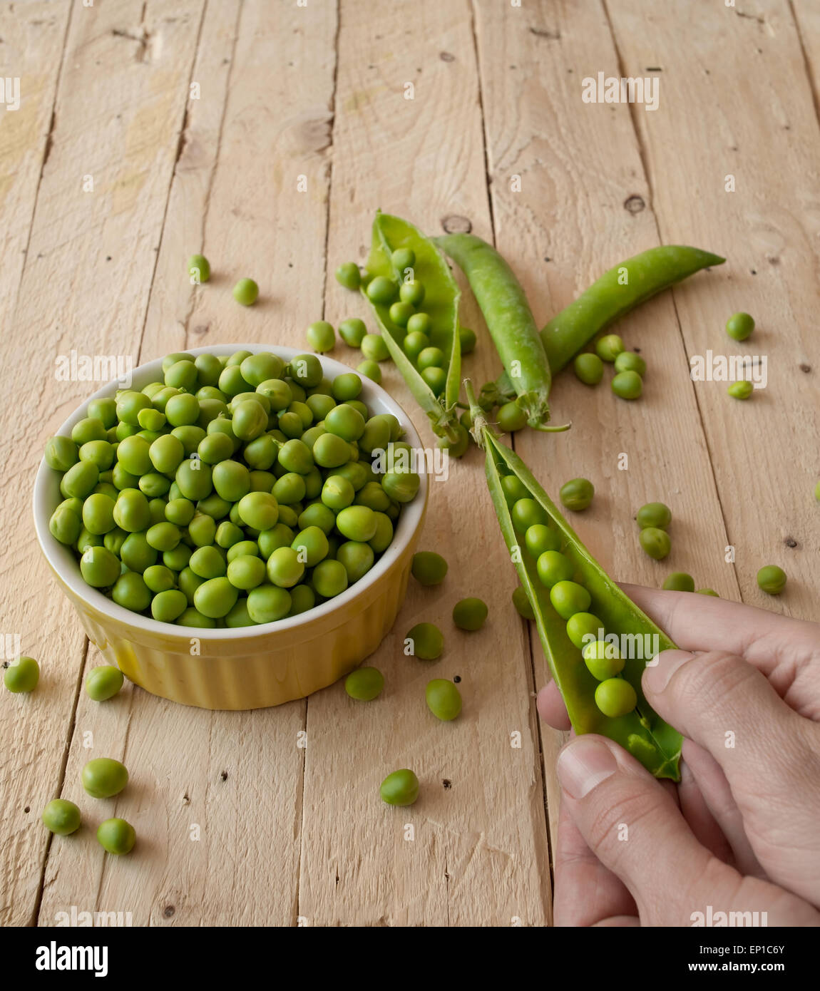 Ecological fresh green peas pods in a wooden rustic table. Stock Photo