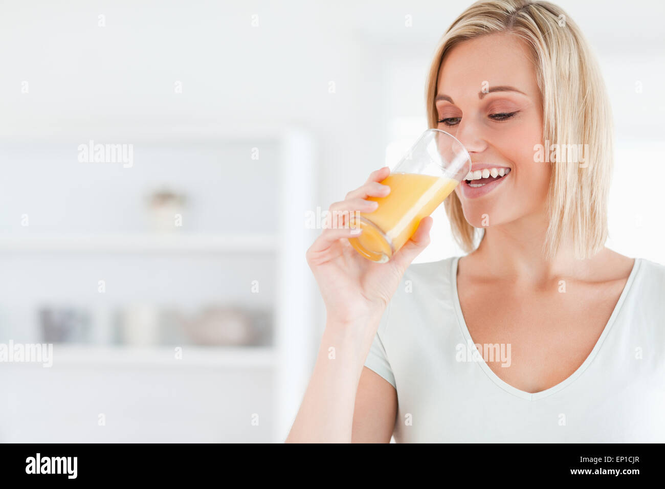 Smiling woman drinking orange juice Stock Photo Alamy