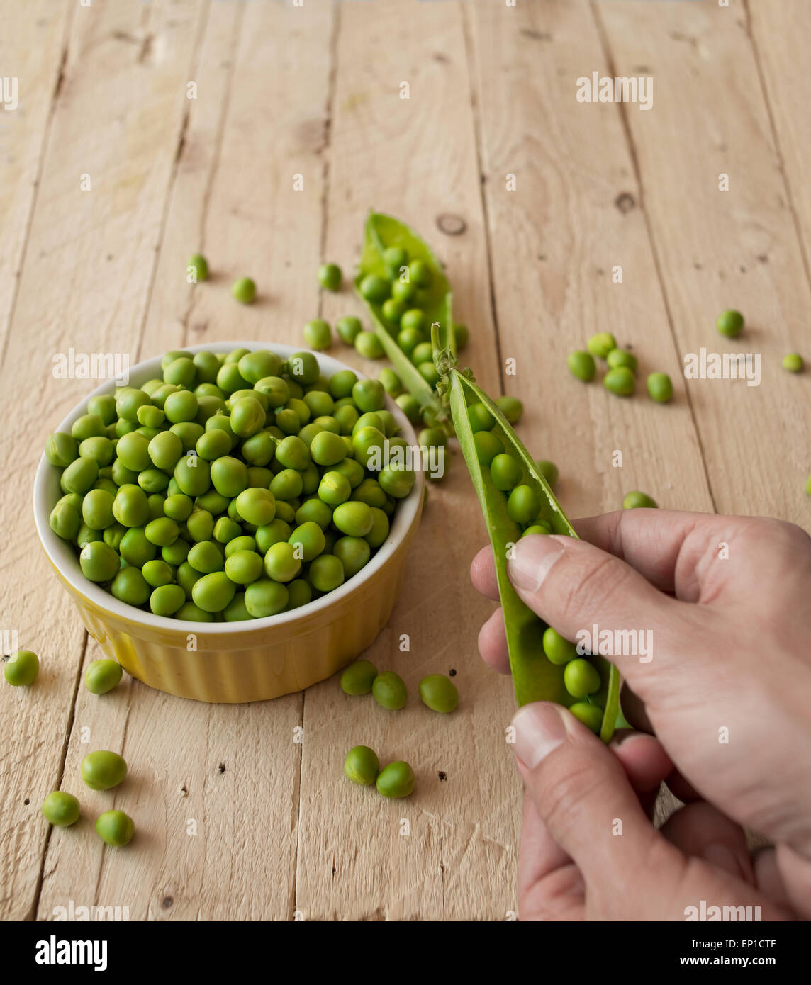 Ecological fresh green peas pods in a wooden rustic table. Stock Photo