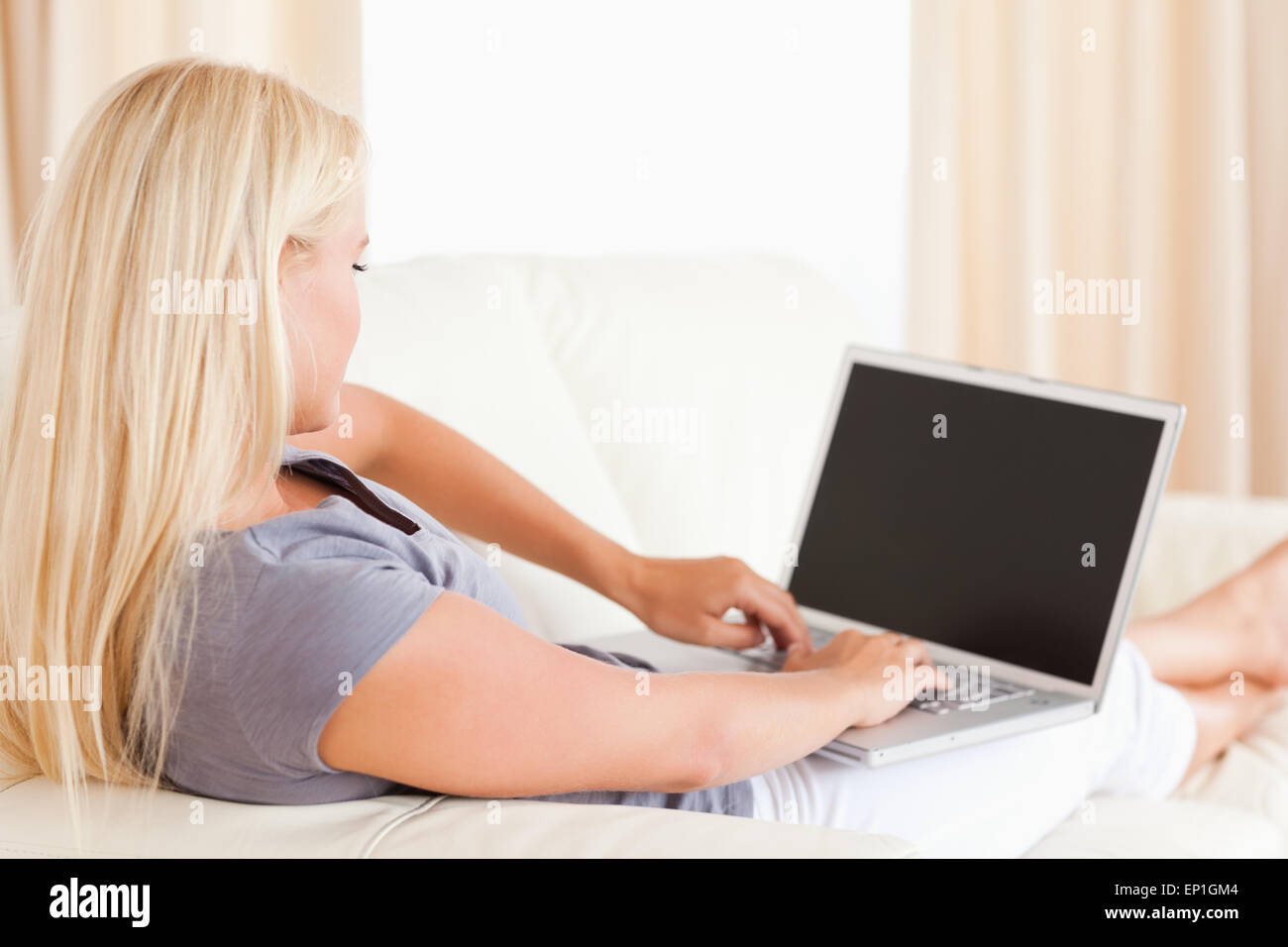 Blonde woman using a laptop Stock Photo - Alamy