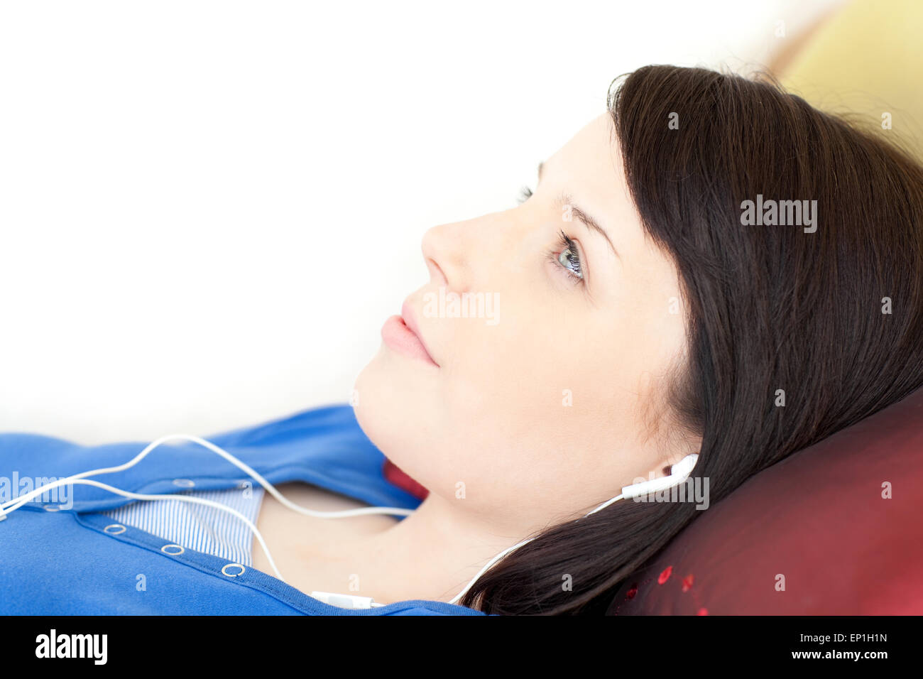 Pretty teen girl listening music lying on a sofa Stock Photo - Alamy