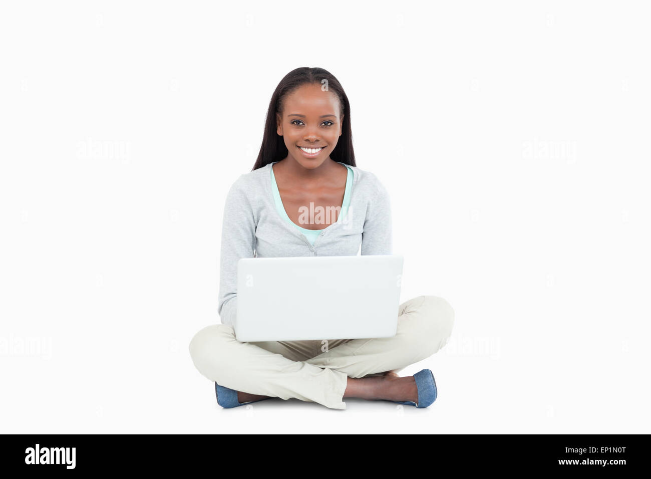 Smiling young woman sitting on the floor with her laptop Stock Photo ...