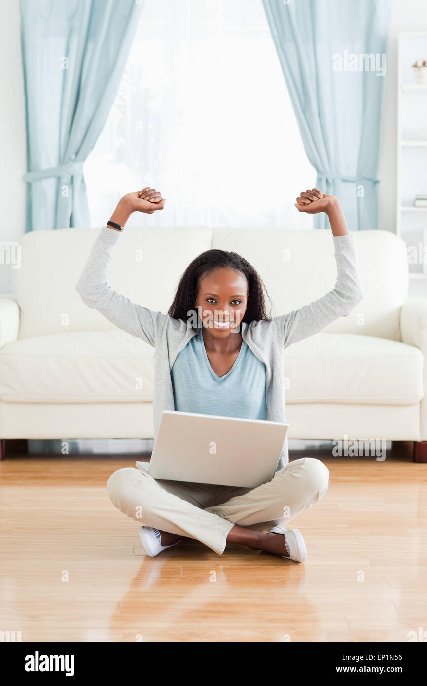 Woman stretching while sitting on the floor with laptop Stock Photo - Alamy