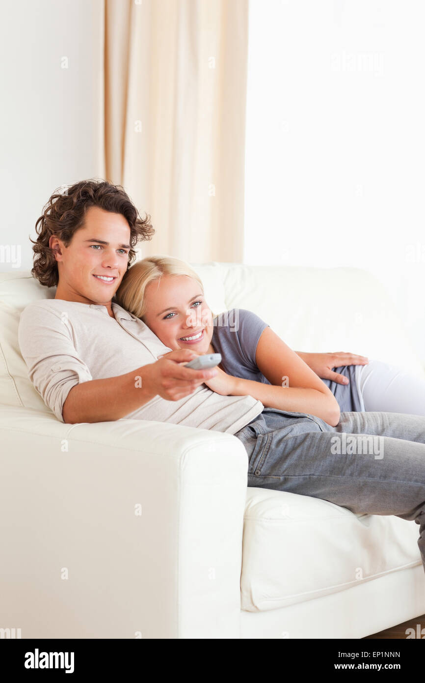 Portrait of a couple cuddling while watching TV Stock Photo - Alamy