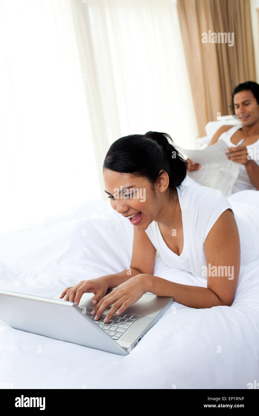 A woman using a laptop lying on the bed Stock Photo - Alamy