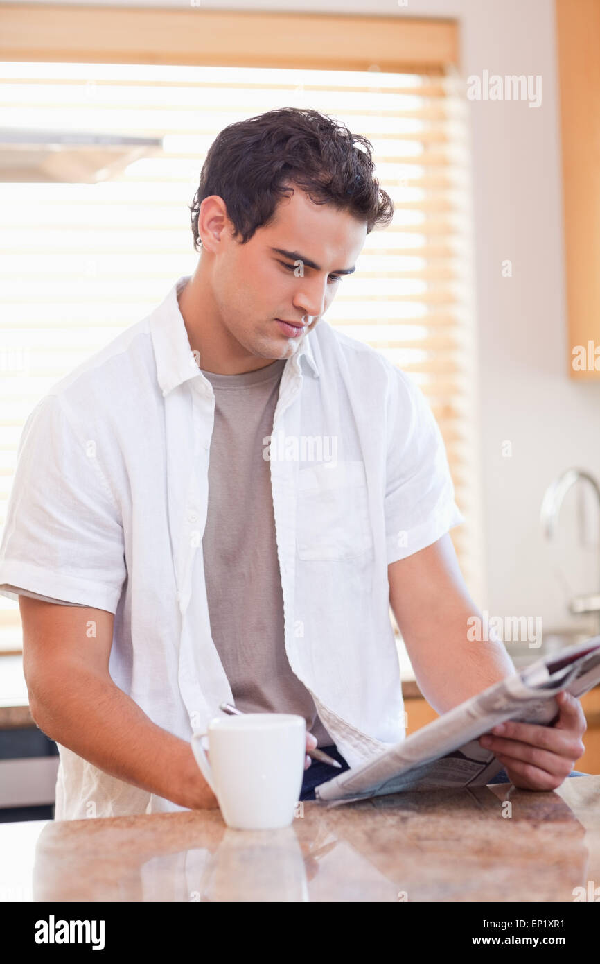 Man Doing Crossword Puzzle In The Kitchen Stock Photo Alamy