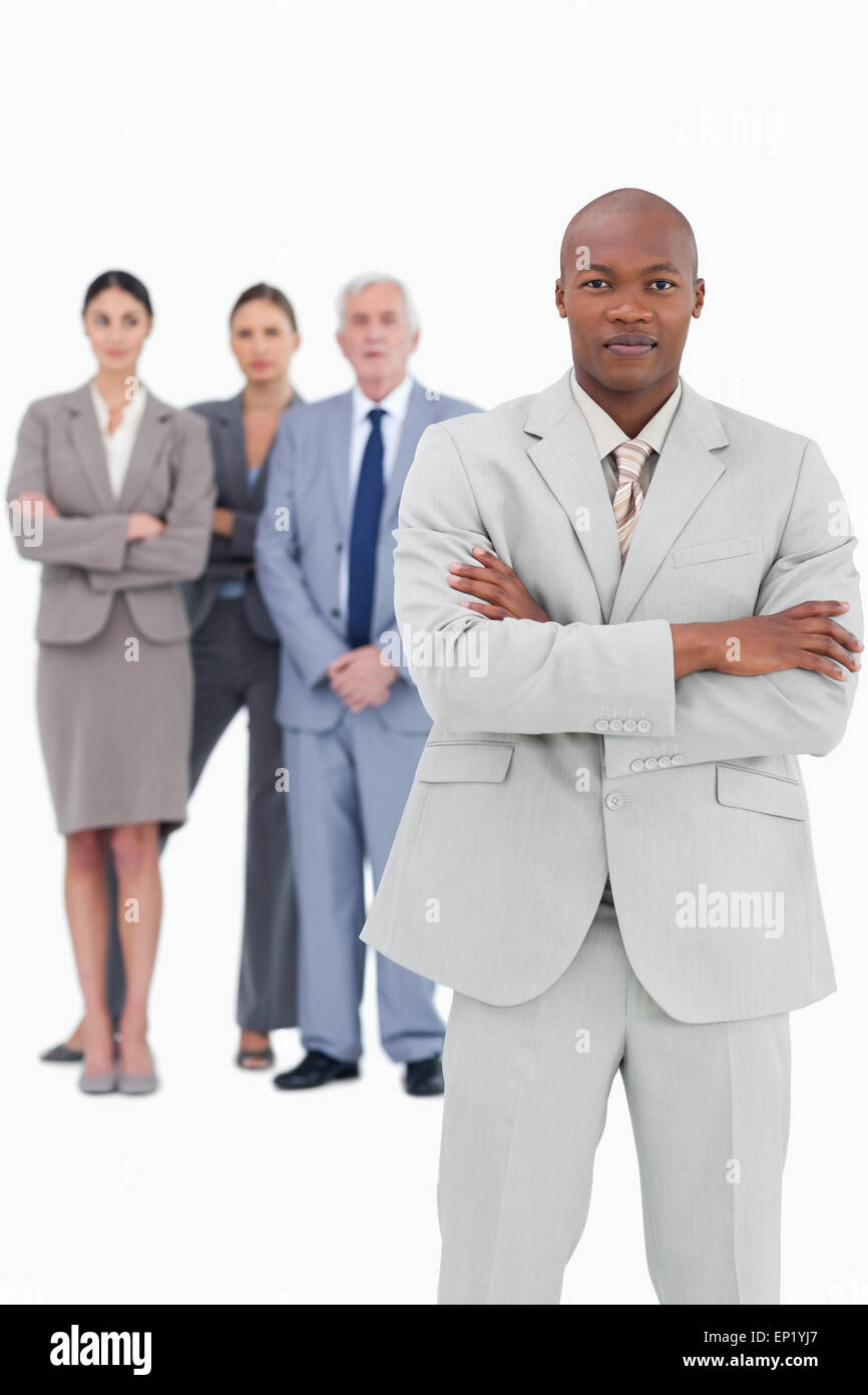 Businessman with folded arms and team behind him Stock Photo - Alamy