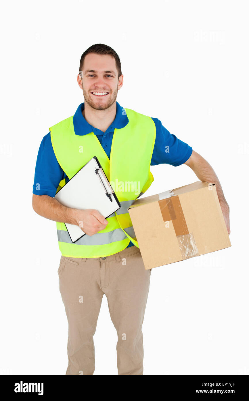 Smiling young delivery man with parcel and delivery note Stock Photo ...