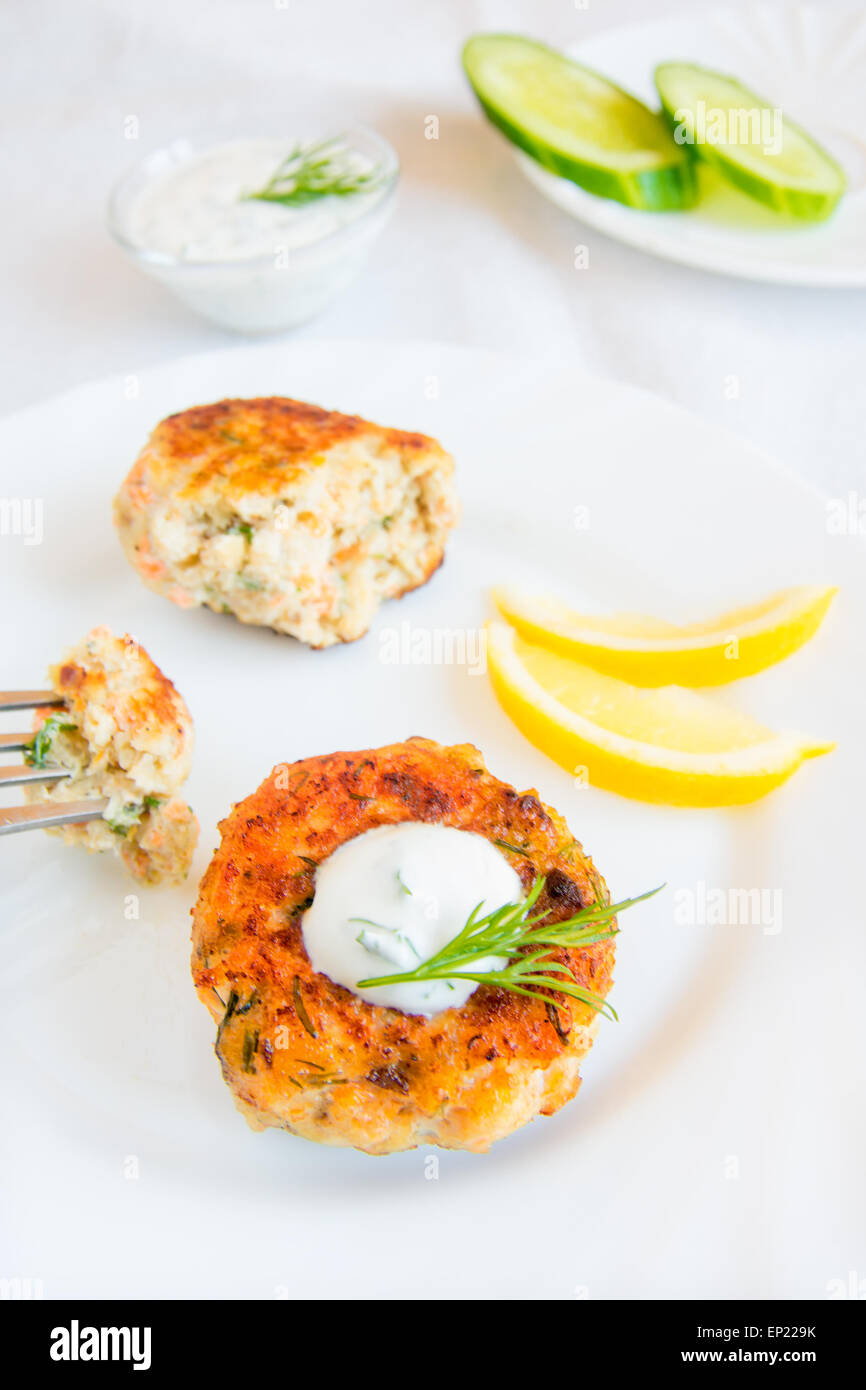 Homemade thai fish cakes (cutlets) with white sauce, dill and lemon on