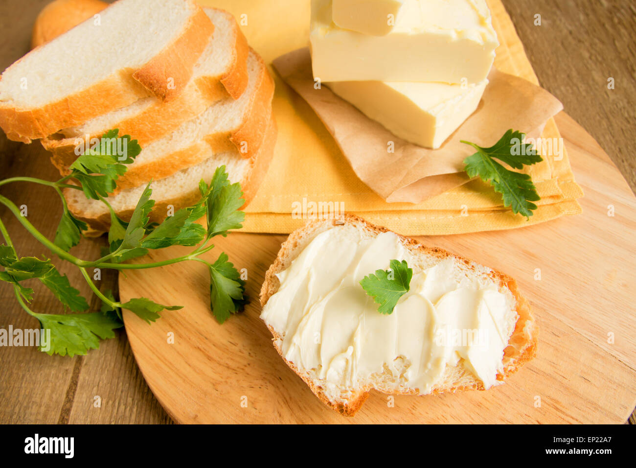 Butter and bread for breakfast, with parsley over wooden table Stock Photo