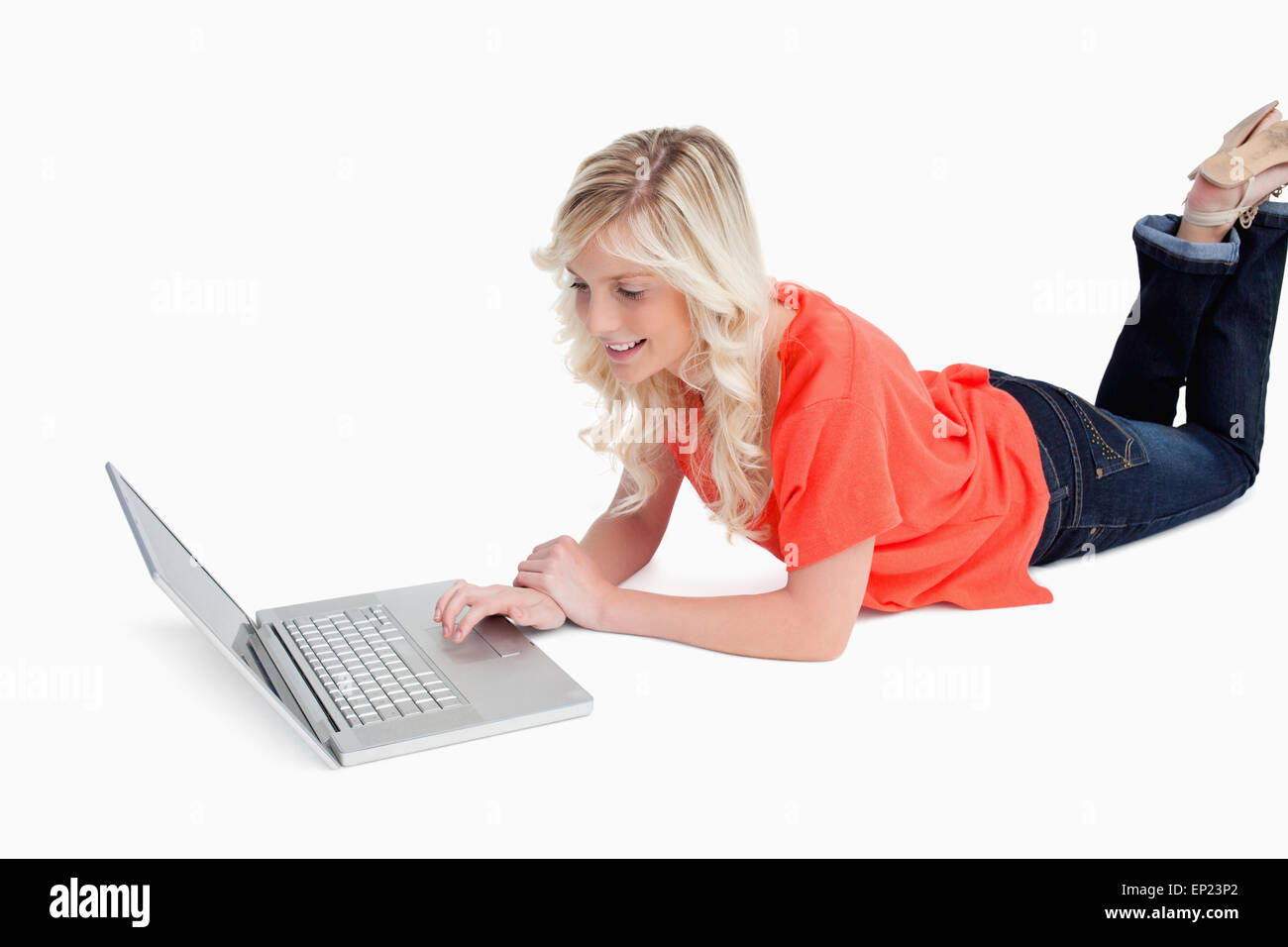 Woman lying down with legs crossed while using her laptop Stock Photo