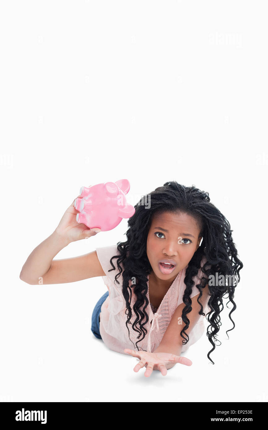 A worried young woman holding an empty piggy bank Stock Photo - Alamy