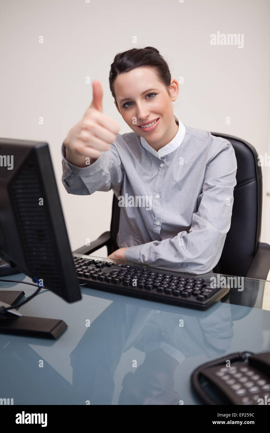 Smiling businesswoman giving thumb up Stock Photo