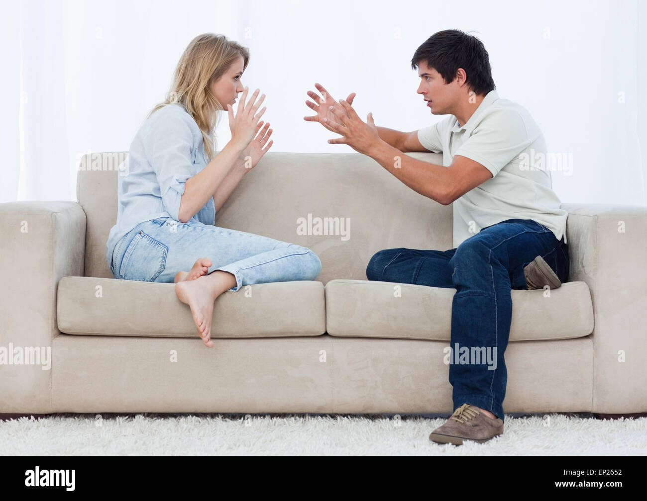 A couple sitting on a couch are having an argument Stock Photo - Alamy