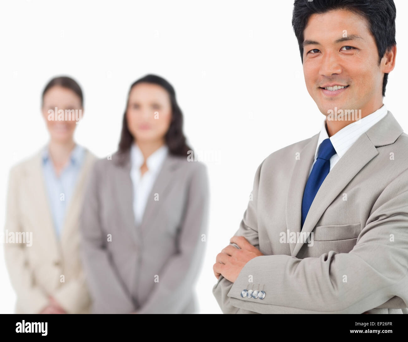 Smiling young businessman with colleagues behind him Stock Photo - Alamy