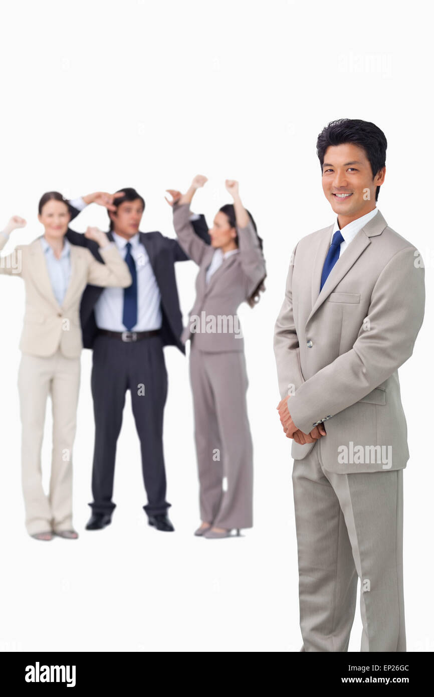 Businessman standing with cheering team behind him Stock Photo - Alamy