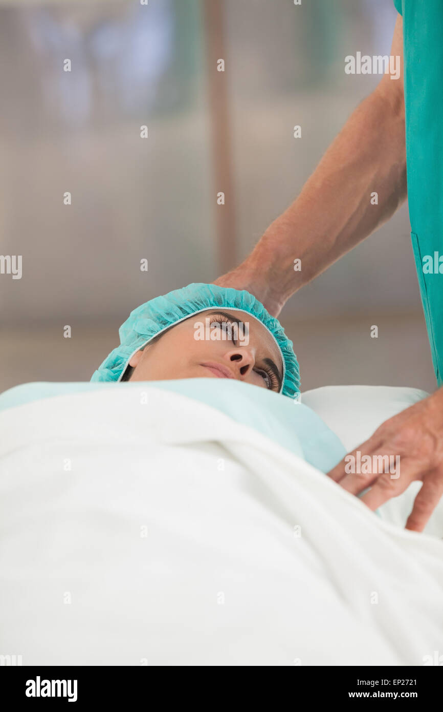 Female patient lying on a bed while looking a surgeon Stock Photo