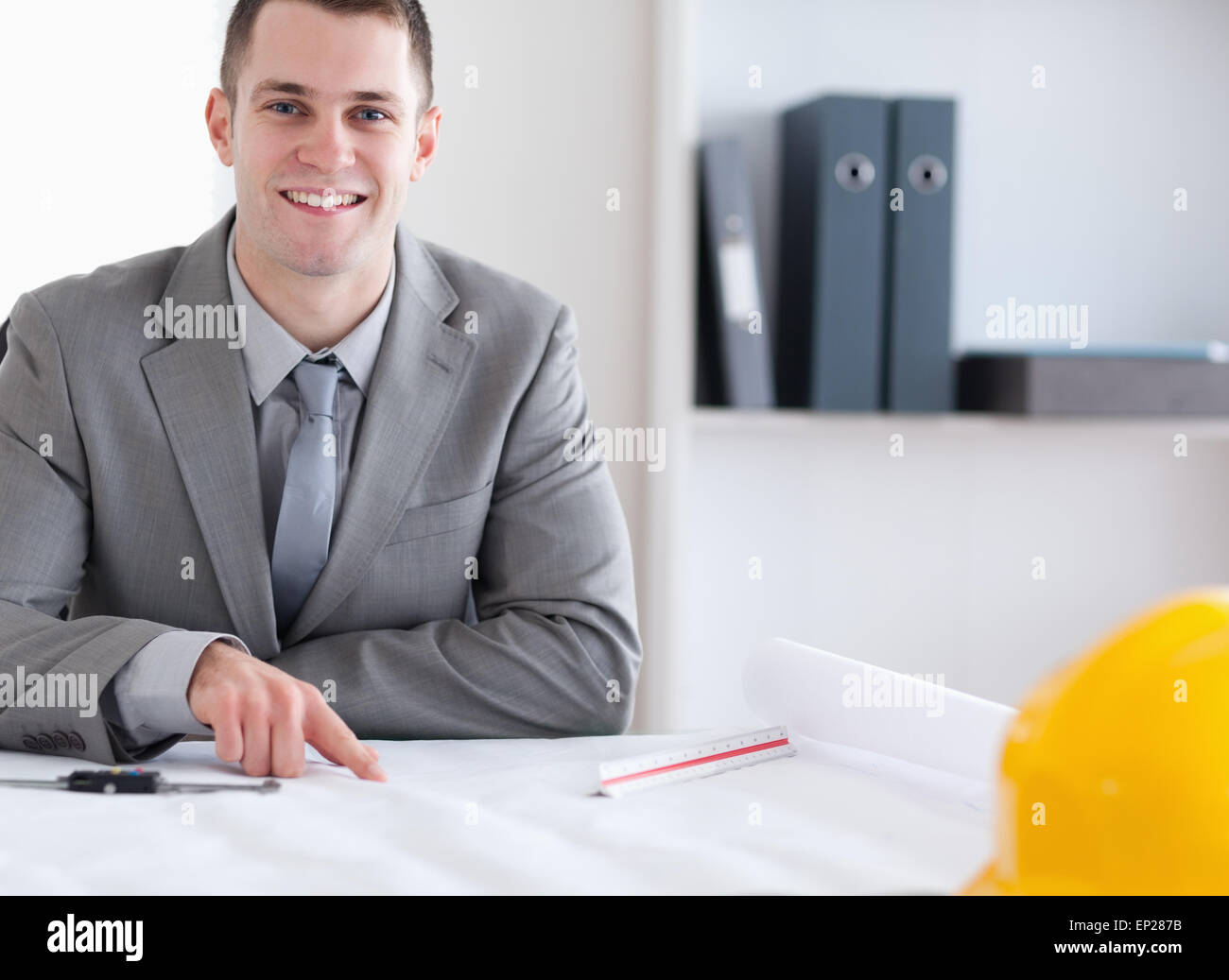 Smiling architect working on a building plan Stock Photo - Alamy