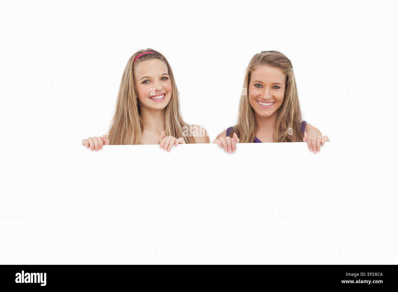 Close-up of two young women holding a blank sign Stock Photo - Alamy