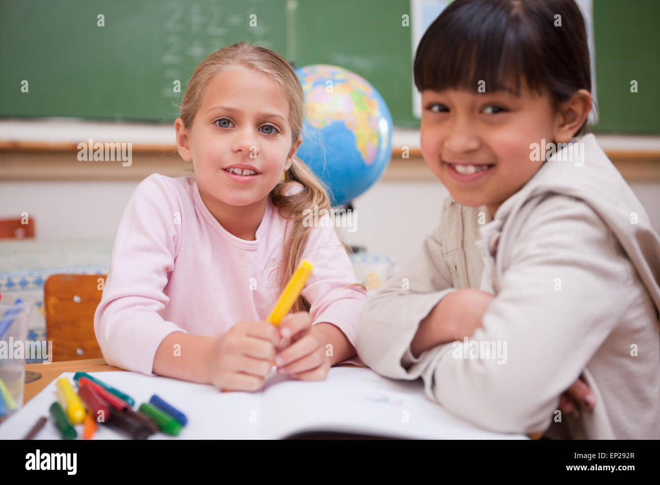 Schoolgirls drawing while looking at the camera Stock Photo - Alamy