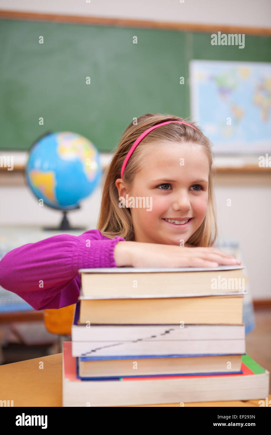 Portrait of schoolgirl posing with a stack of books Stock Photo - Alamy