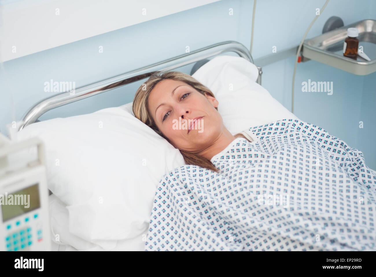 Woman lying on a bed while looking at camera Stock Photo - Alamy