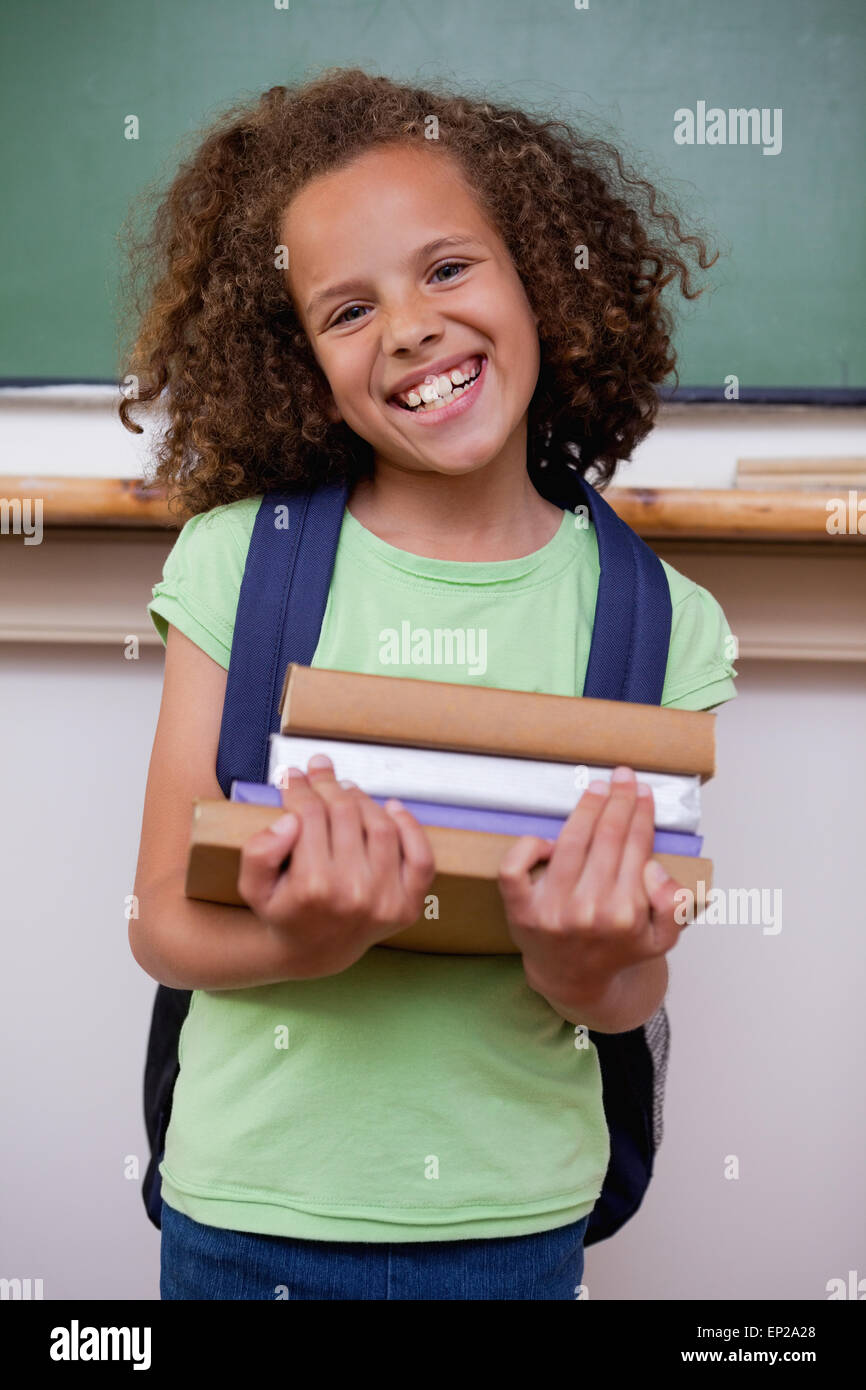 Portrait of a smiling schoolgirl holding her books Stock Photo - Alamy