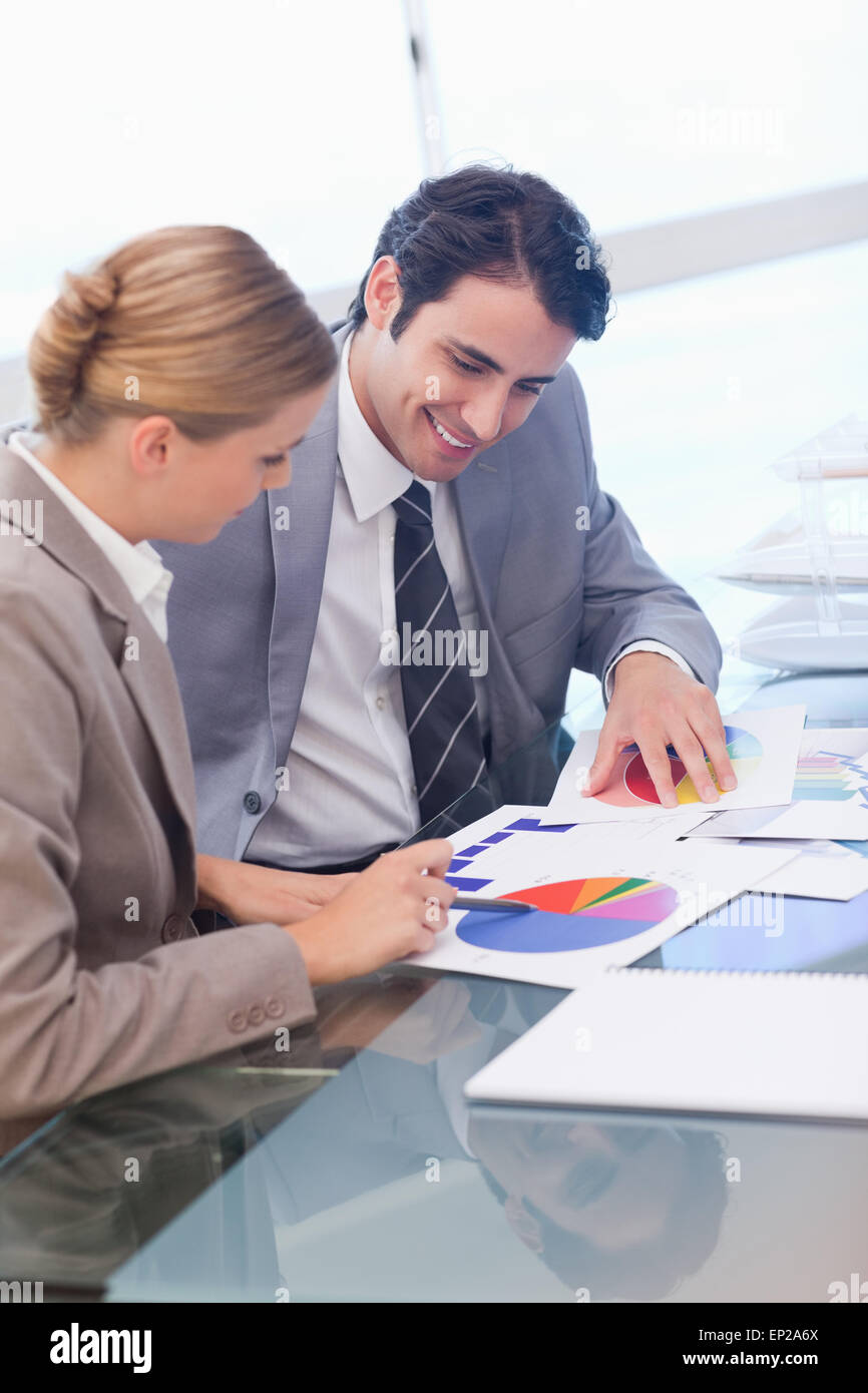 Portrait of smiling business people studying statistics Stock Photo - Alamy