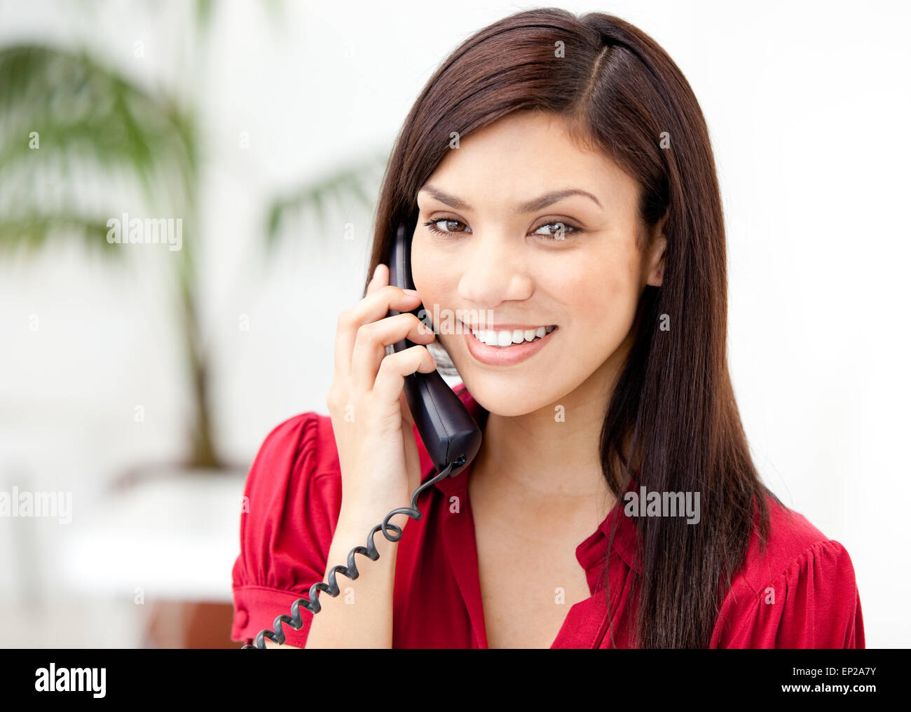 Девушка позвонить телефон номер. Женщина с телефонной трубкой. Девушка с телефоном в офисе. Девушка говорит по телефону и улыбается. Девушка с трубкой телефона.