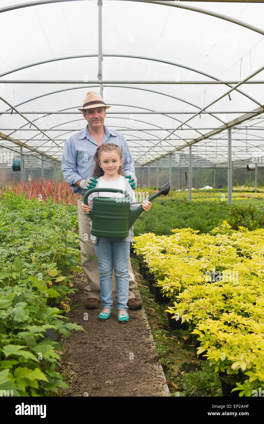 Gardener and little girl holding a watering can Stock Photo - Alamy