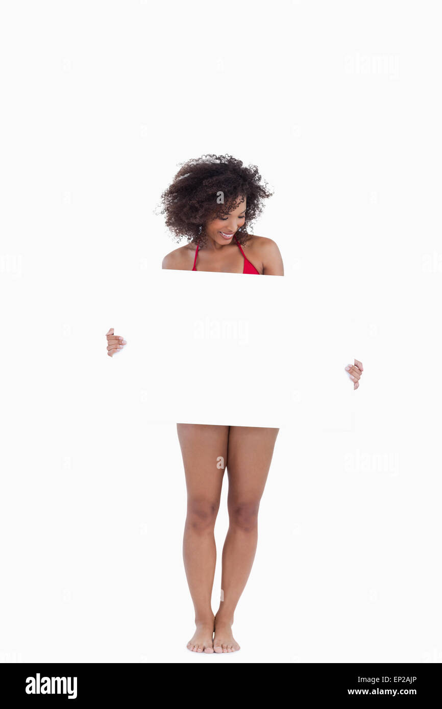 Smiling woman holding a blank poster while wearing a swimsuit Stock Photo