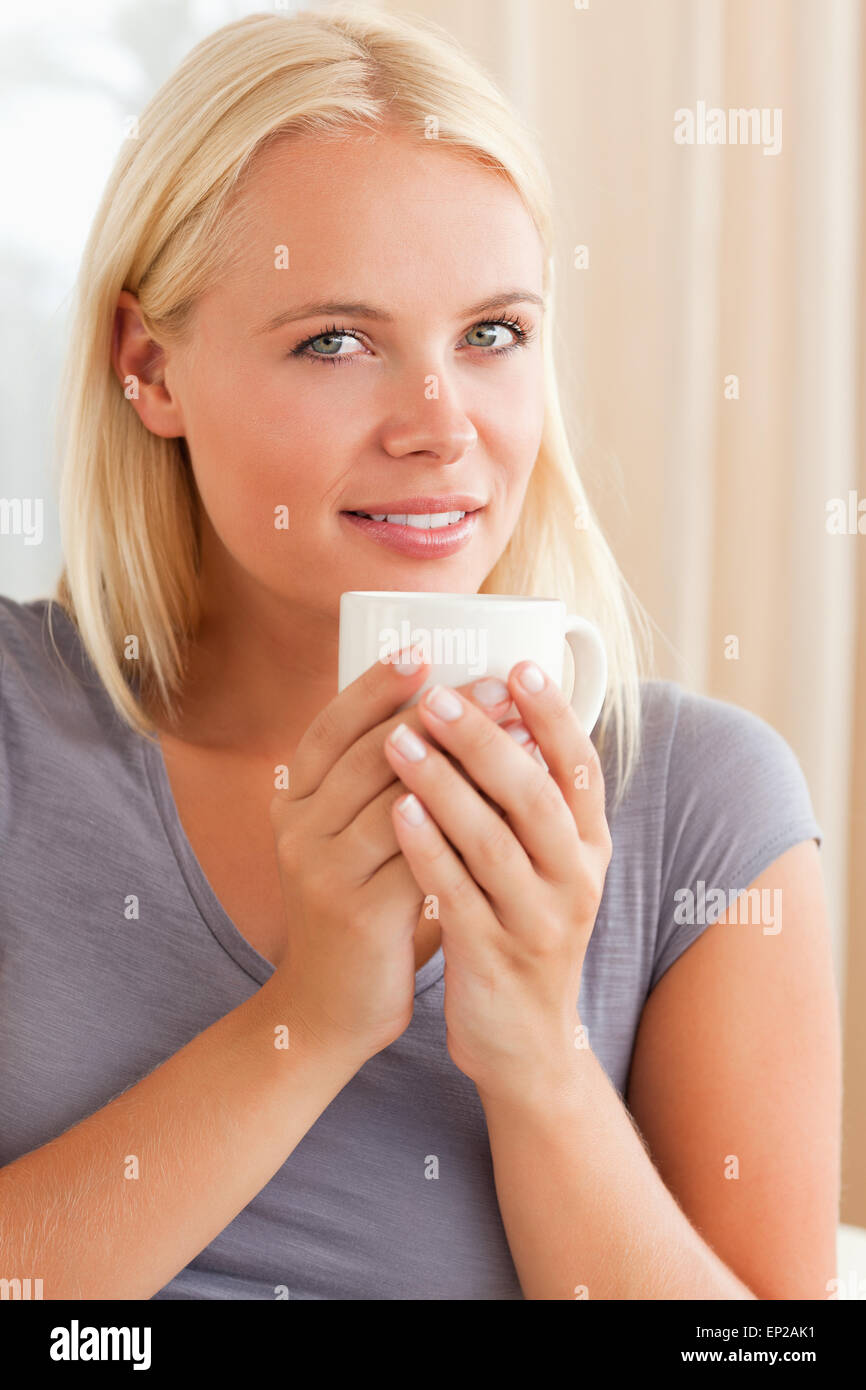 Portrait of a calm woman sitting on a couch with a cup of tea Stock ...