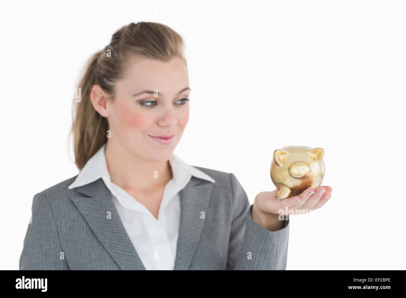 Woman smiling at the piggy bank in her hand Stock Photo - Alamy