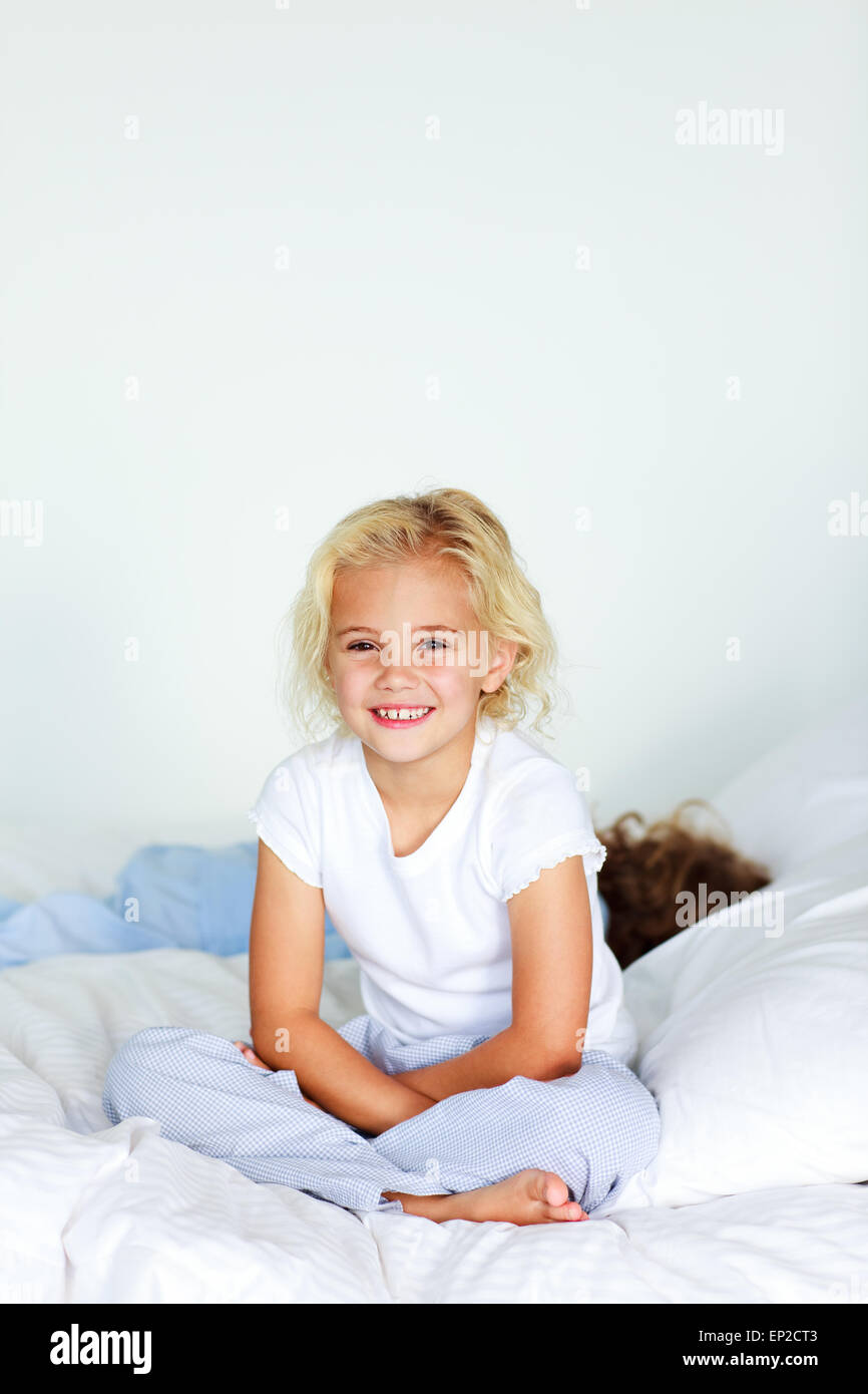 Little girl with brother on the bed Stock Photo