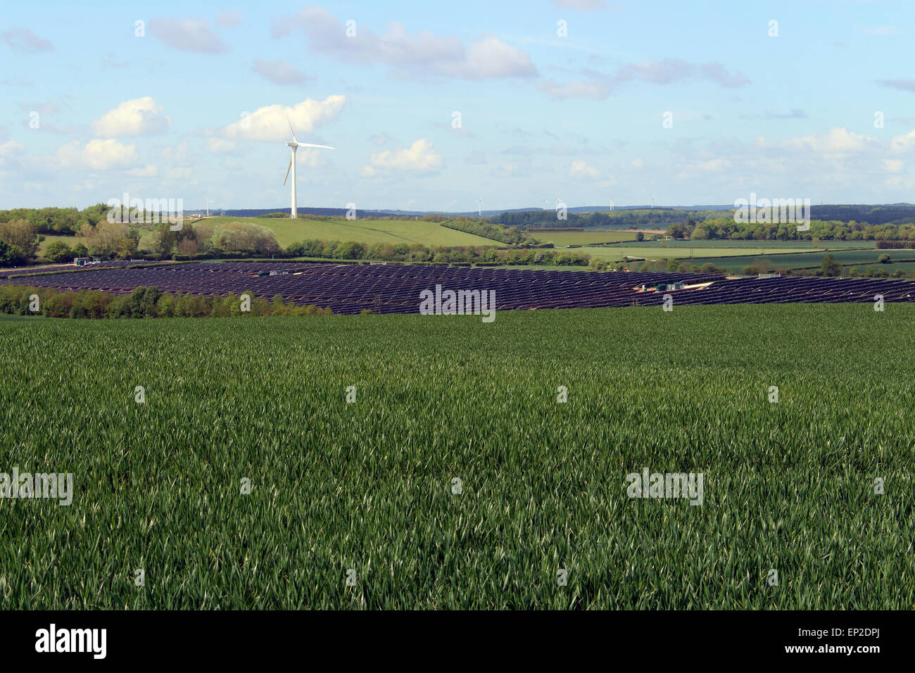Wind turbine stands guard over a solar farm at Bilsthorpe Nottinghamshire England Stock Photo