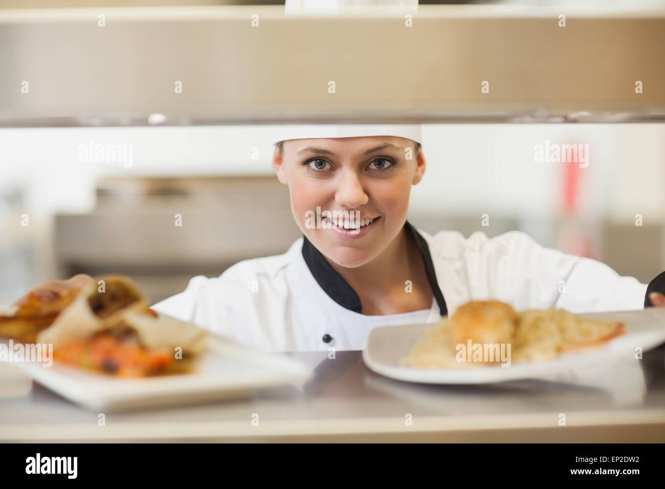Chef handing dinner plates through order station Stock Photo Alamy
