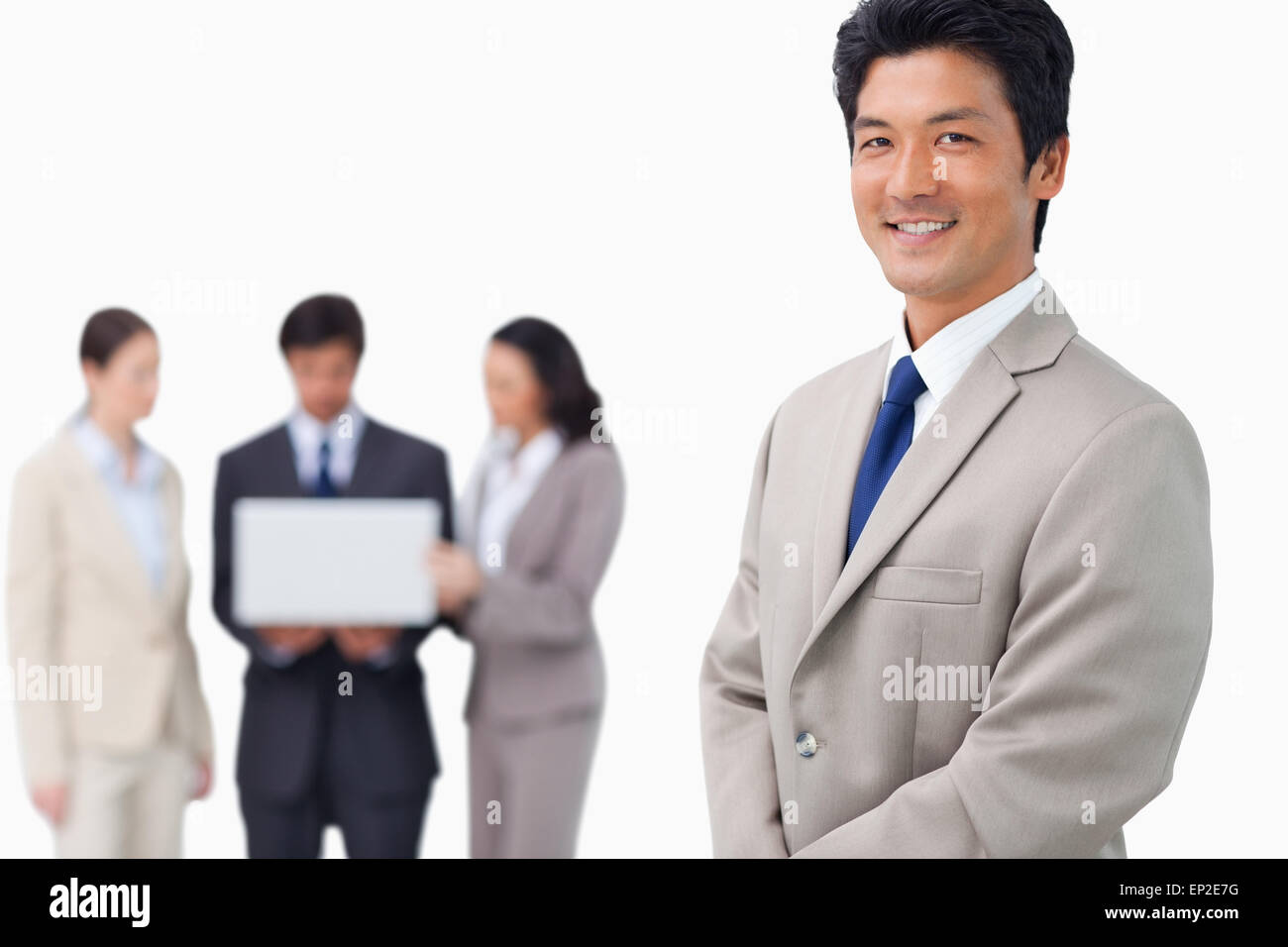 Businessman with colleagues and laptop behind him Stock Photo - Alamy