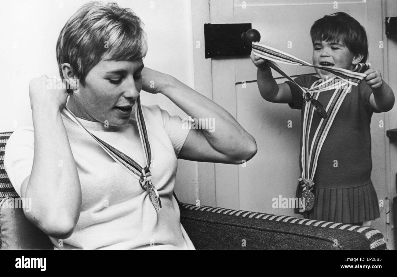 For a moment Alison Rand displays a touching lack of awe for the Olympic medals that put her mother Mary Rand among the world'd supreme athletes. 29th October 1964 Stock Photo