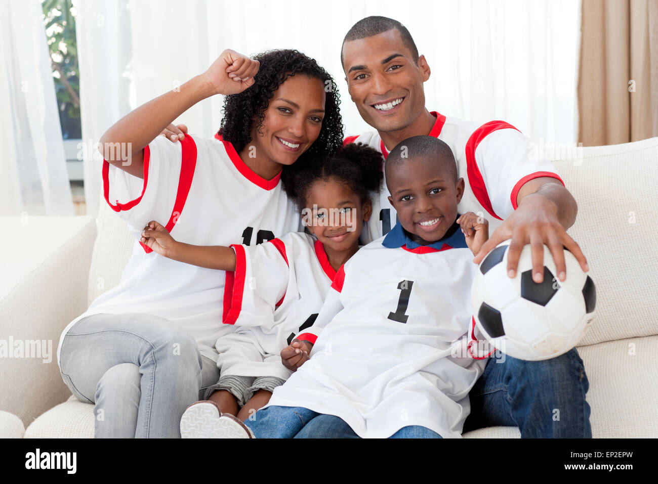 Afro-American family celebrating a football goal Stock Photo