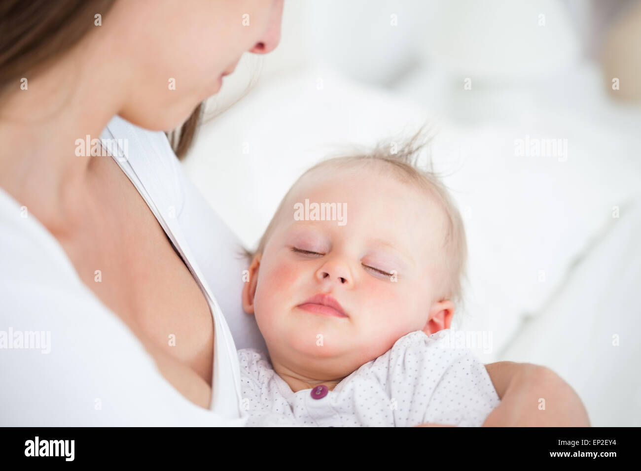 Baby falling asleep in the arms of her mother Stock Photo Alamy