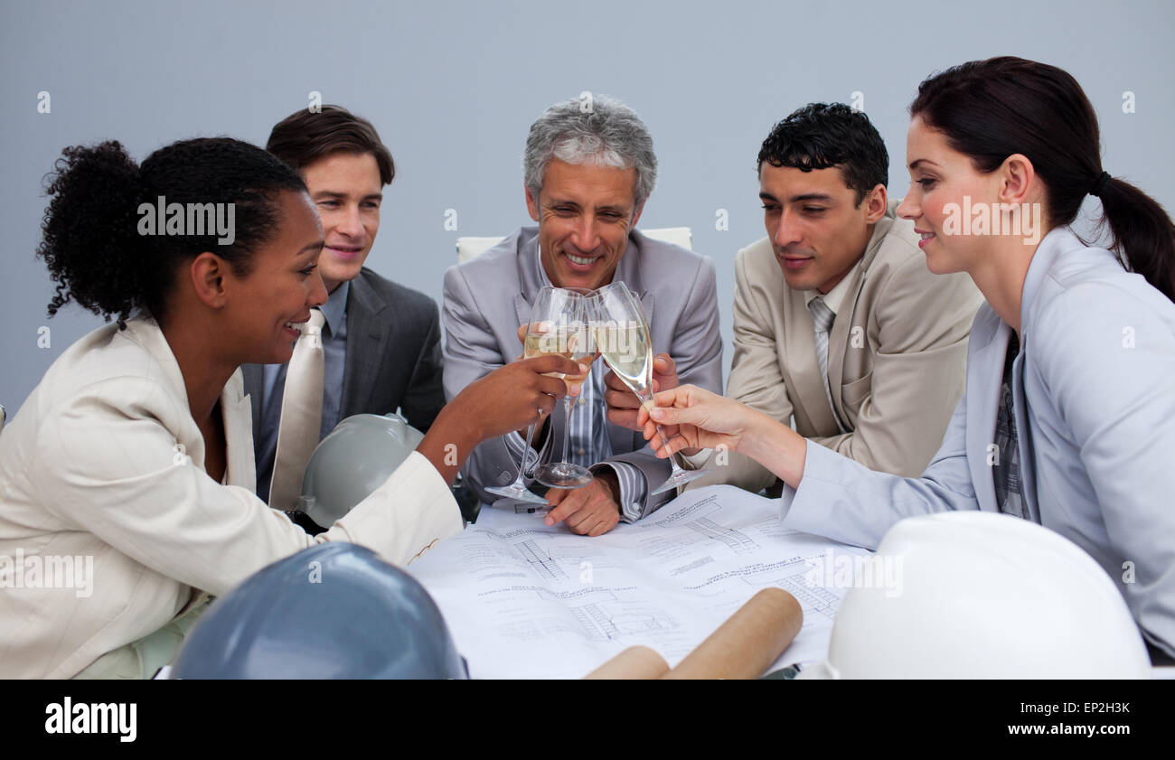 Happy architectutal team celebrating a success with champagne Stock Photo
