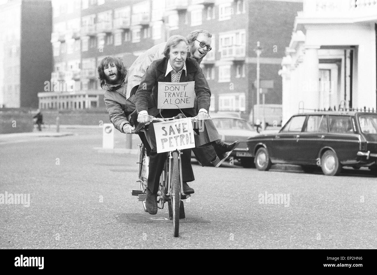 The Goodies, on the perfect answer to petrol rationing, ride their three seater tandem bicycle in London, Wednesday 21st November 1973. The Goodies Trio are Tim Brooke-Taylor, Graeme Garden & Bill Oddie. Stock Photo