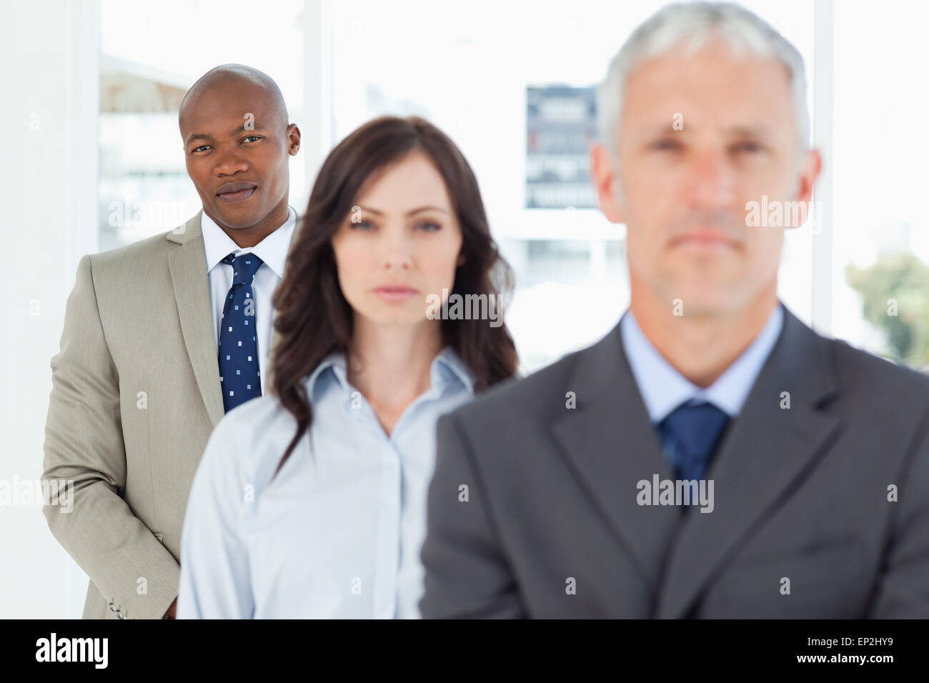 Young and serious businessman following two members of his team Stock Photo