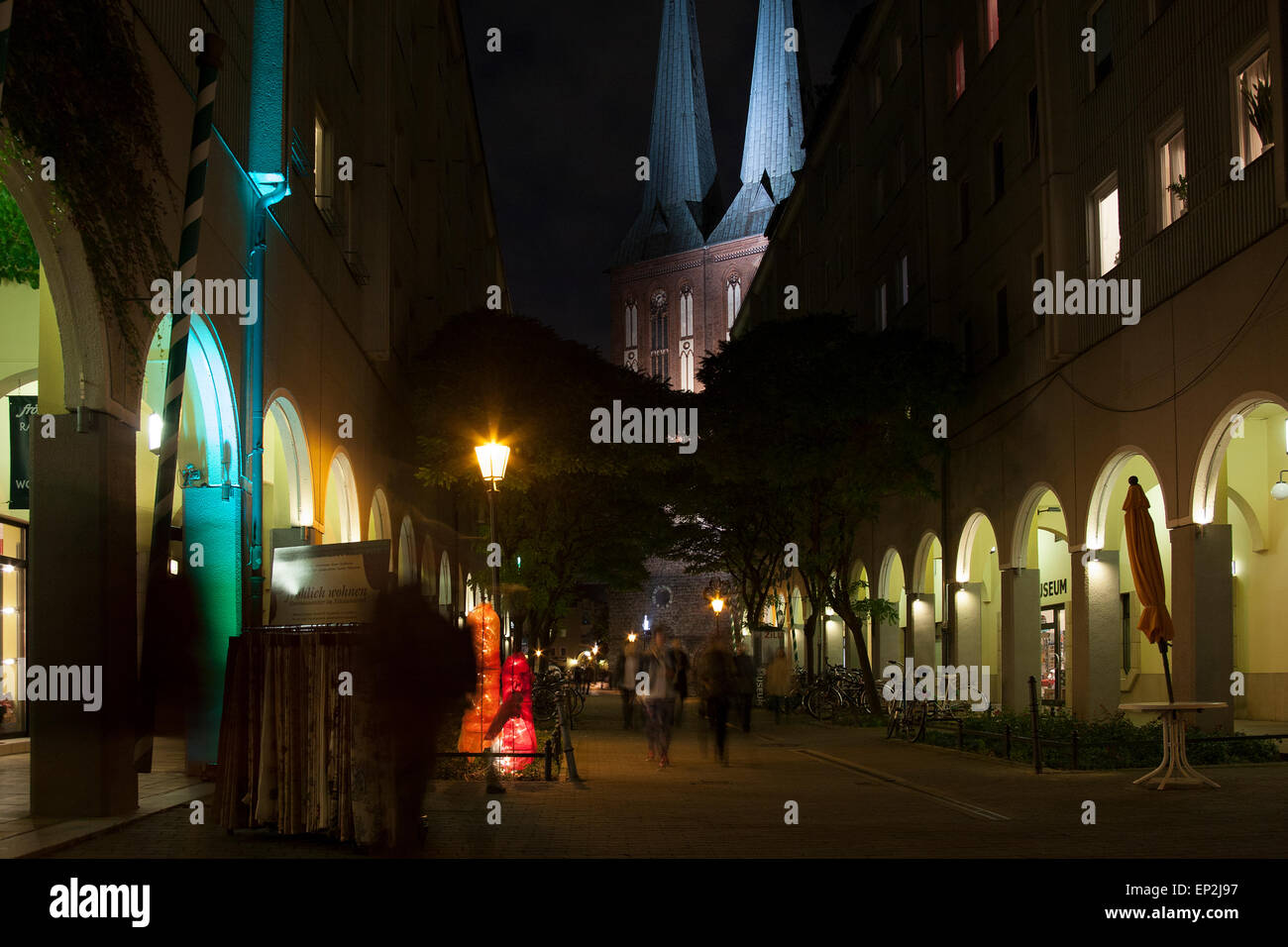 Shopping area in Berlin at night showing the twin spires of Nikolaikirche, the oldest church in Berlin, in the background. Stock Photo