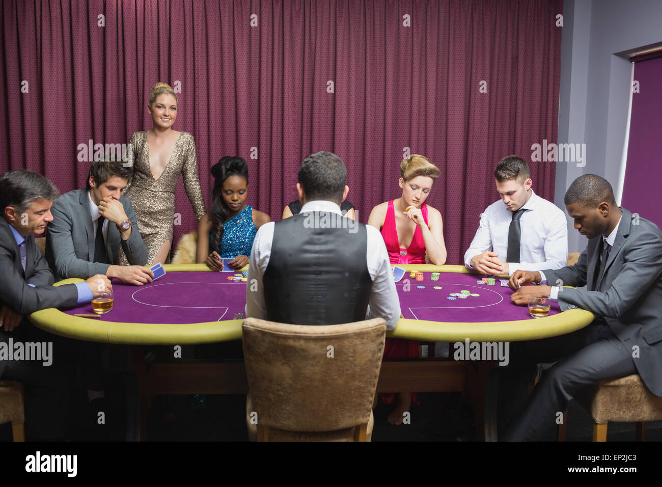 People sitting at the casino table with woman standing Stock Photo