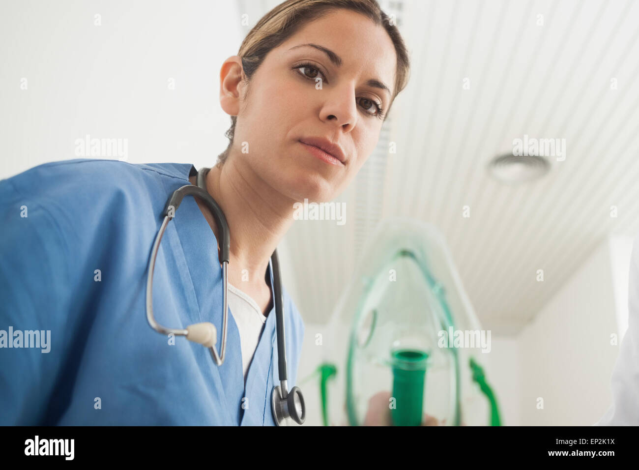 Nurse holding an oxygen mask while looking at camera Stock Photo - Alamy