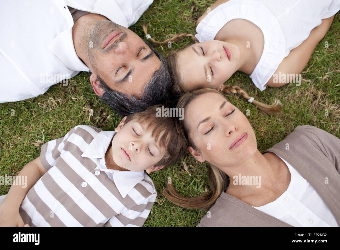Family sleeping in a park with heads together Stock Photo Alamy