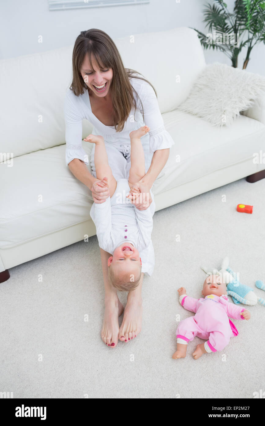 Mother playing with a baby while sitting on a sofa Stock Photo - Alamy