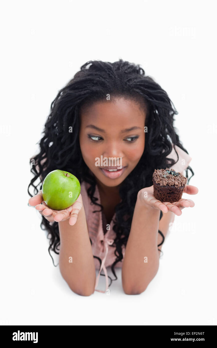 An apple and a bun are held up on the palms of a young womans hands Stock Photo